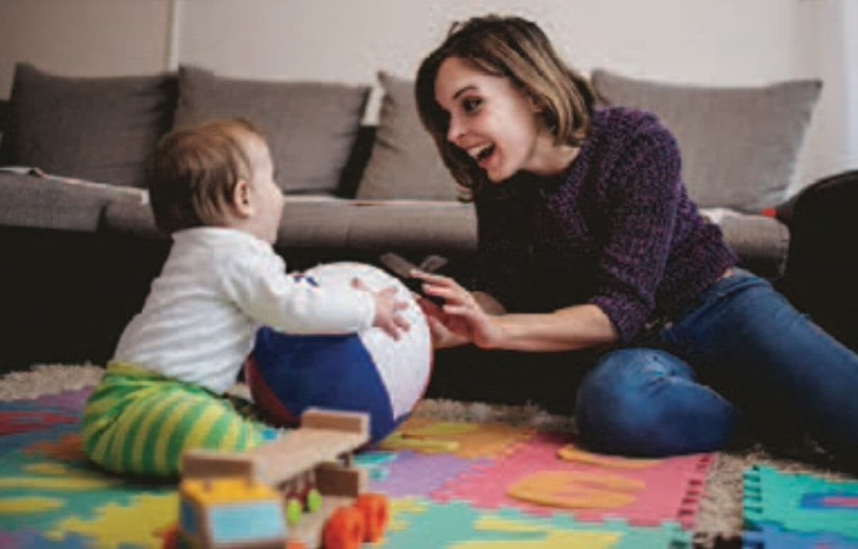 Caregiver plays ball with infant
