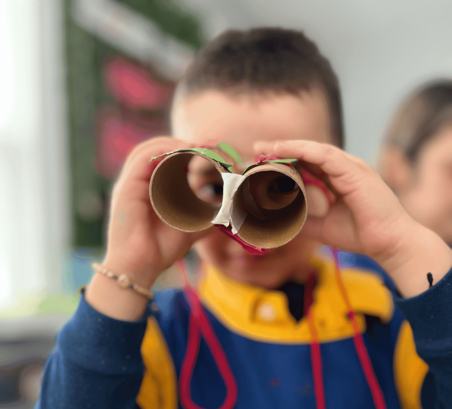boy holding paper tube binoculars