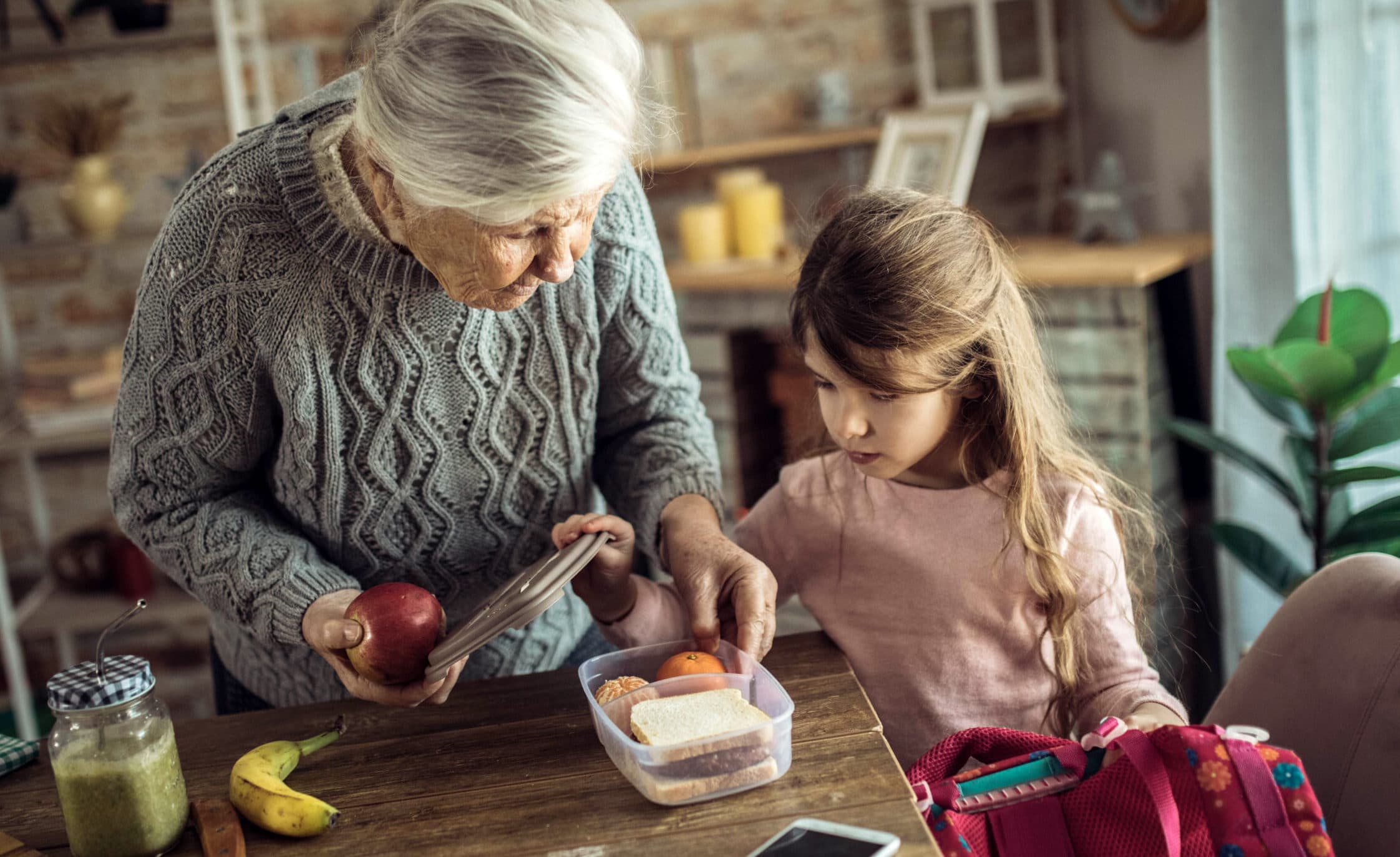 caregiver and child packing a school lunch